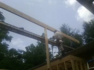 Carpenter setting a ridge beam over a new addition frame — Ice Dam Removal by Roofing Brothers in Coolin