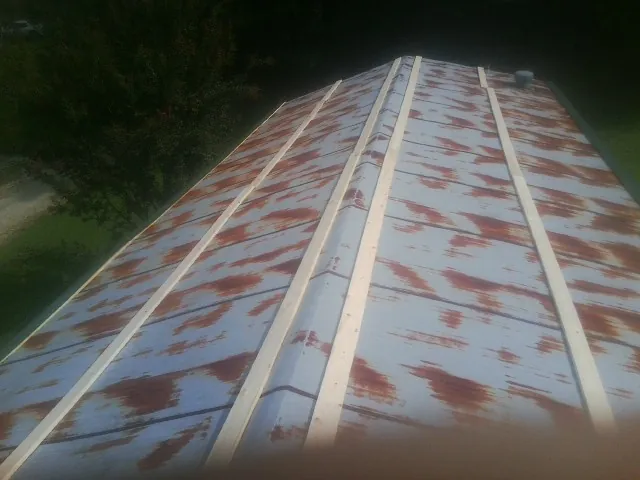 Rusted metal roof panels with new wood purlins before replacement — Storm Damage Roof Repair in Coolin by Roofing Brothers