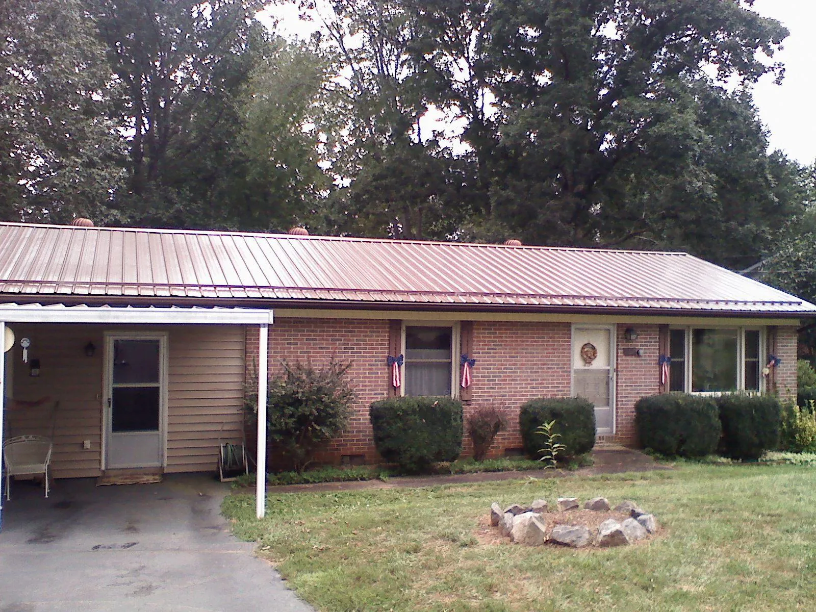Bronze metal roof and carport on a brick ranch home — Roof Repair work by our crew in Coolin
